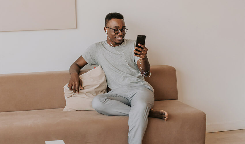 A smiling man looking at his mobile phone