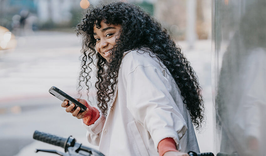 A smiling lady sitting on a bike